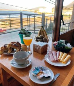 乌斯怀亚Balcones del Beagle Apart的一张带早餐食品和一杯橙汁的桌子