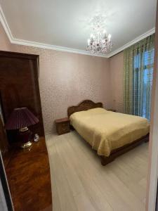 甘贾Veyasum Guest House的一间卧室配有一张床和一个吊灯