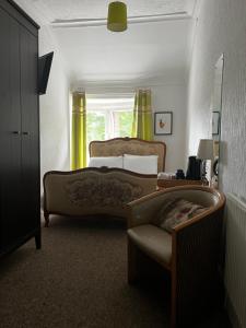 巴洛赫Norwood Guesthouse-Loch Lomond的卧室配有床、椅子和窗户。