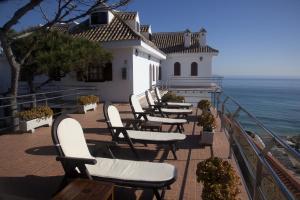 洛斯卡尼奥斯德梅卡玛德弗伦特旅馆的俯瞰大海的阳台的一排椅子