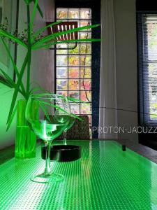 贝尔蒙特·德米兰达zentral club apartamento protón-jacuzzi的一张绿桌,上面有一杯葡萄酒