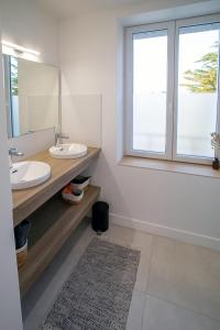 凯卢昂Ty Meham, à 700m de la plage et Meneham, grand terrain calme的浴室设有2个水槽、镜子和窗户。