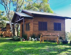 圣弗朗西斯科-迪保拉Cabanas dos Pinheiros的小木屋前面设有长凳