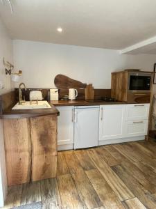 多姆Le Relais des galets的厨房铺有木地板,配有白色橱柜。