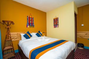 加德满都Kwabahal Boutique Hostel的一间卧室设有一张黄色墙壁的大床