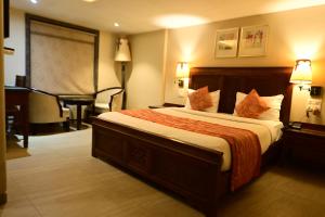 孟买Hotel Sai Inn的酒店客房设有一张大床和一张书桌。