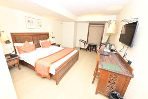 孟买Hotel Sai Inn的酒店客房,配有床和电视