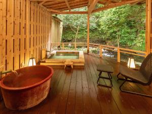 河津町Mizumari的木制甲板上的大型浴缸,配有热水浴缸