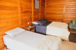 多明戈斯马丁斯Pousada Gagno的木墙客房的两张床