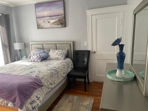 波士顿Boston Luxury 2 Bedroom Private Condo的卧室配有1张床、1张桌子和1把椅子