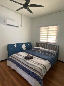 亚娄Aisyah Homestay Arau的一间卧室配有一张蓝色的床和吊扇