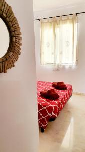 贝纳尔马德纳Benalmarina Sea View Apartments的窗户客房内的一张红色的床