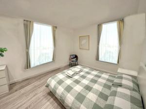 伦敦2 minutes from Hyde Park, Private Room F的卧室设有绿色和白色的床和2扇窗户