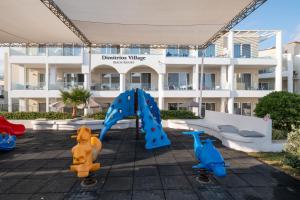 罗希姆诺Dimitrios Village Beach Resort的公寓大楼前的游乐场