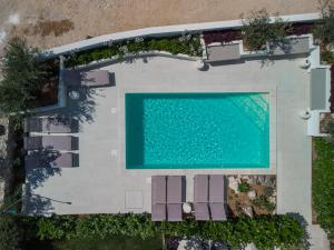 诺瓦利娅VILLA CALA, Hotel Rooms&Apartments的享有带椅子的游泳池和游泳池的顶部景致