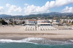 罗希姆诺Dimitrios Village Beach Resort的海滩上摆放着一束白色椅子,还有一处度假胜地