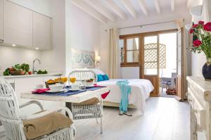 马略卡岛帕尔马卡塔利娜精品公寓式酒店的厨房以及带1张床和1张桌子的卧室