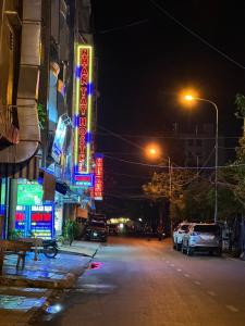 芹苴Nhan Tay Hostel的 ⁇ 虹灯标志的城市街道