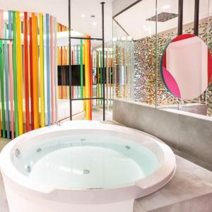 马德里Hotel Avenue - Lovely hotel的一间多彩玻璃隔板的大浴缸