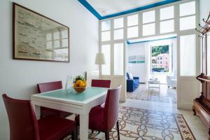 波托菲诺Blue by PortofinoHomes的一间设有白色桌子和红色椅子的用餐室