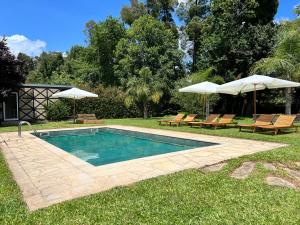 蓬德利马Quinta do Moinho da Ínsua的一个带两把椅子和遮阳伞的游泳池