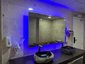 马拉加GOOD VIBES ONLY Capsule Hostel Malaga的浴室设有黑色水槽和镜子