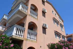 茨里克韦尼察拉万达公寓的带阳台和粉红色鲜花的砖砌建筑