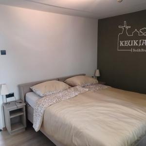 克伊克B&B Keukja Cuijk的一间卧室设有两张床和黑白墙