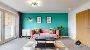 卡迪夫Stunning Cardiff City Apartment! Sleeps 8的客厅设有粉红色的沙发和绿色的墙壁