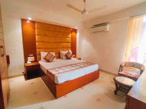 古尔冈The Angel Hotel & Suites near Medanta的配有一张床和一把椅子的酒店客房