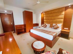 古尔冈The Angel Hotel & Suites near Medanta的酒店客房设有一张大床和一张桌子。