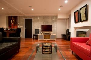 二世古Udelka A的客厅配有红色沙发和电视
