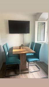 科佩尔Apartments Nina的一张带蓝色椅子的餐桌和一台电视