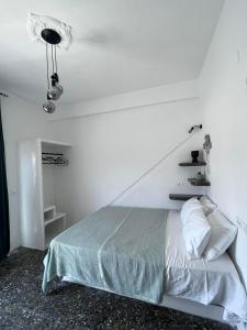 阿达玛斯suite diminutif的白色的卧室,配有床和白色的墙壁