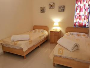 马尔萨斯卡拉Charming apartment-wifi-sleeps 5的一间卧室设有两张床和一张桌子上的台灯。