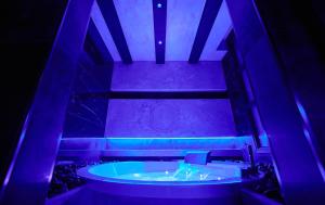福贾Mamaco I Teatro Rooms的一间设有紫色灯浴缸的客房