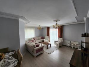 BostancıDeniz manzaralı klimalı daire的客厅配有沙发、椅子和桌子