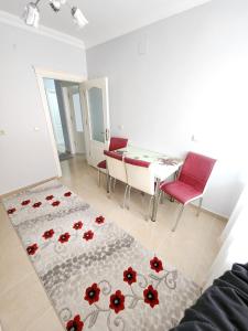 BostancıDeniz manzaralı klimalı daire的客厅配有桌子和红色椅子