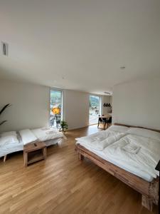 巴尔斯塔尔The R Apartment Engelberg, KLIMA, NEU, Balkon, Parking的客房内设有两张床,铺有木地板,设有窗户。