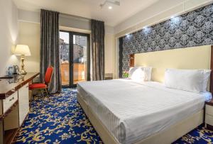 埃里温Royal Plaza by Stellar Hotels, Yerevan的配有一张床和一张书桌的酒店客房