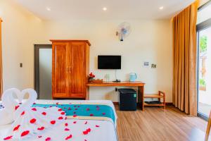 富国Palm Bay Resort Phu Quoc的一间酒店客房,配有一张床和一台电视