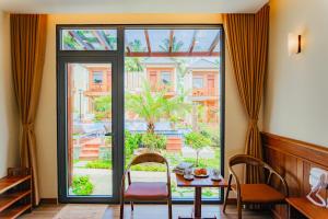 富国Palm Bay Resort Phu Quoc的一间带桌子和大窗户的用餐室