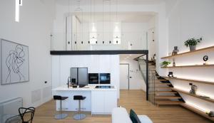 米兰Loft Milano Manifatture2的厨房拥有白色的墙壁和带凳子的楼梯