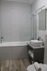 锡比乌Green Apartment的白色的浴室设有浴缸和水槽。