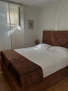 斯塔里格勒Secret Place Apartment的一间卧室配有一张大床和木制床头板