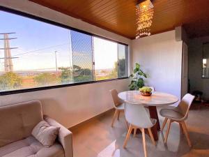 巴西利亚3 Quartos Com Vista Espetacular的客厅配有桌椅和大窗户