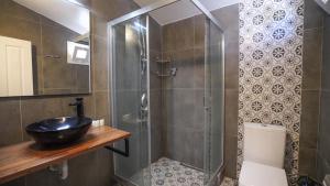 达特恰Datça Dirik Surf Beach Hotel的一间带水槽和玻璃淋浴的浴室