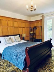 巴顿尼德伍的Canalside Cottage的一间卧室配有一张大床和一个吊灯。