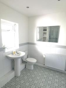 巴顿尼德伍的Canalside Cottage的白色的浴室设有水槽和卫生间。