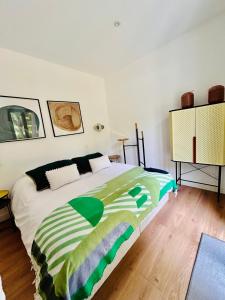 BeignonLodge avec spa au coeur de Brocéliande的一间卧室配有一张带绿色和白色毯子的床